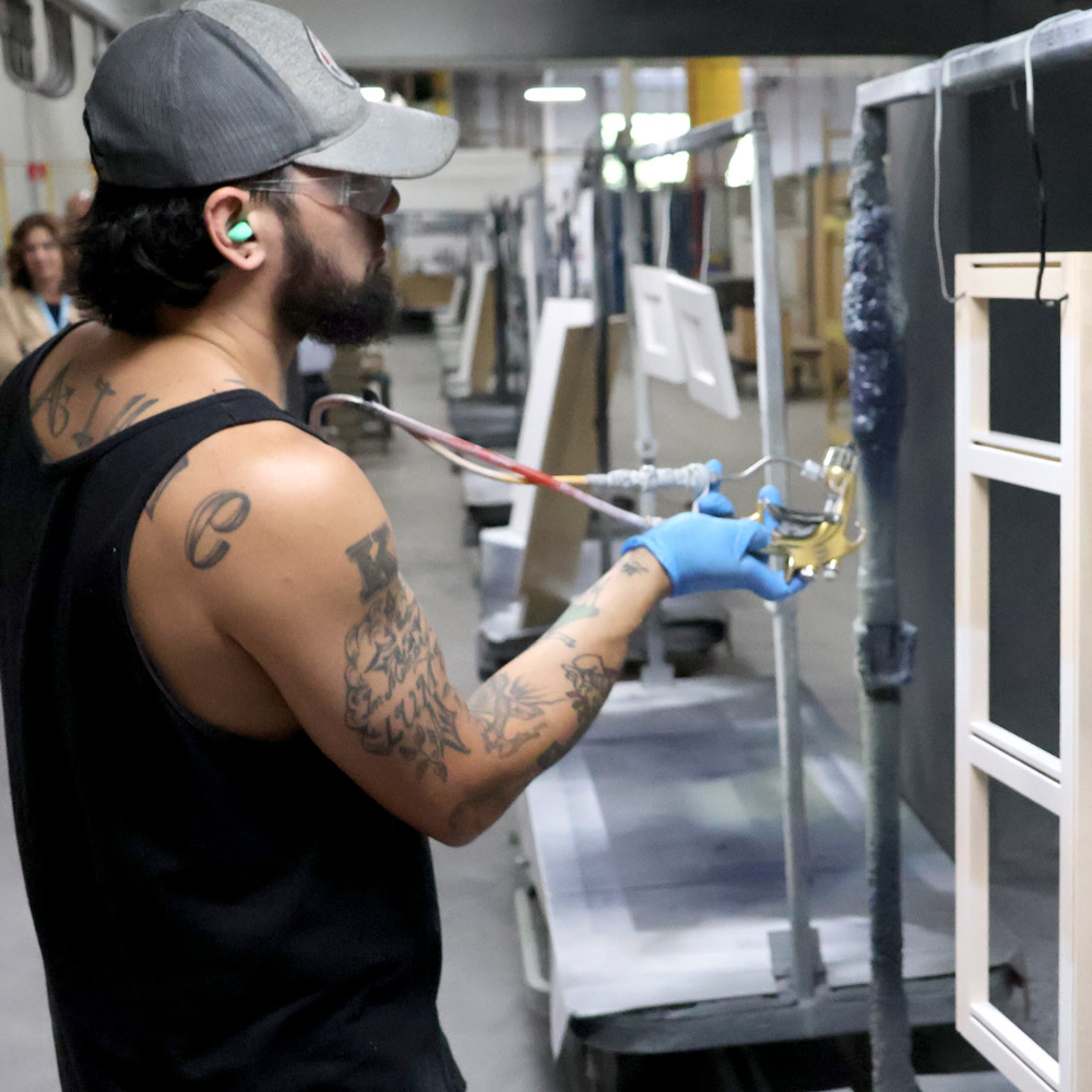 Bertch employee spraying face frame