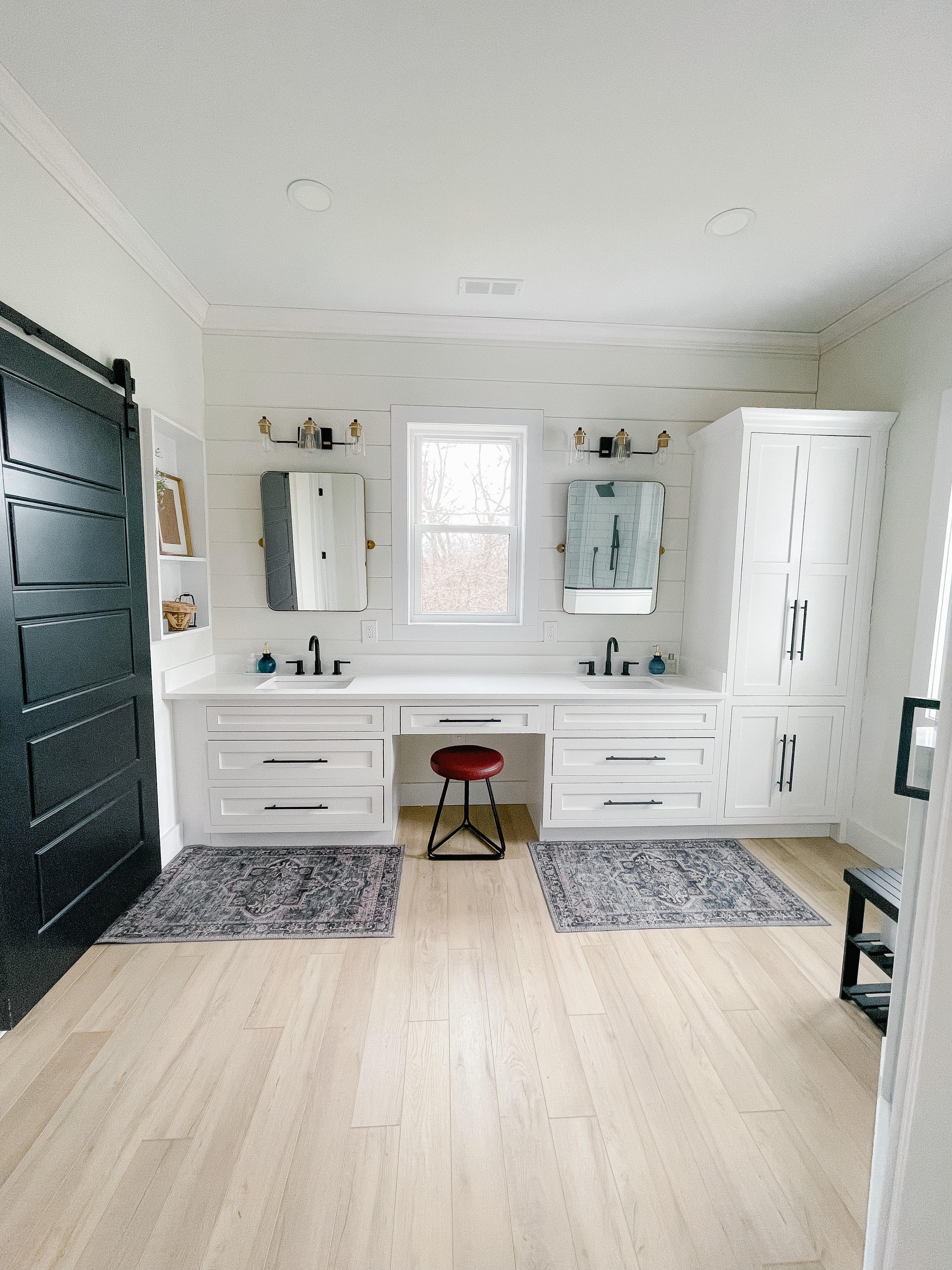 Light colored vanity and floors with dark door