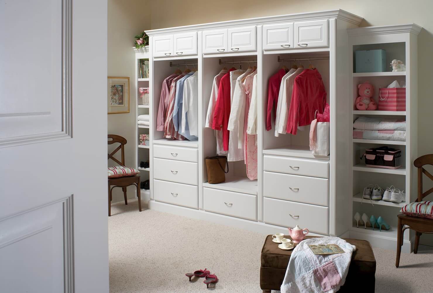 White painted closet cabinets and bedroom storage by Bertch.