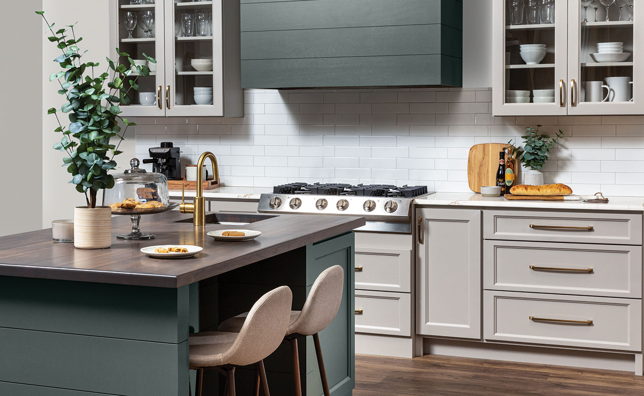 A close up of a modern wood hood with shiplap details and a hunter green painted finish surrounded by off-white, light gray cabinets with a dramatic flat panel door style.