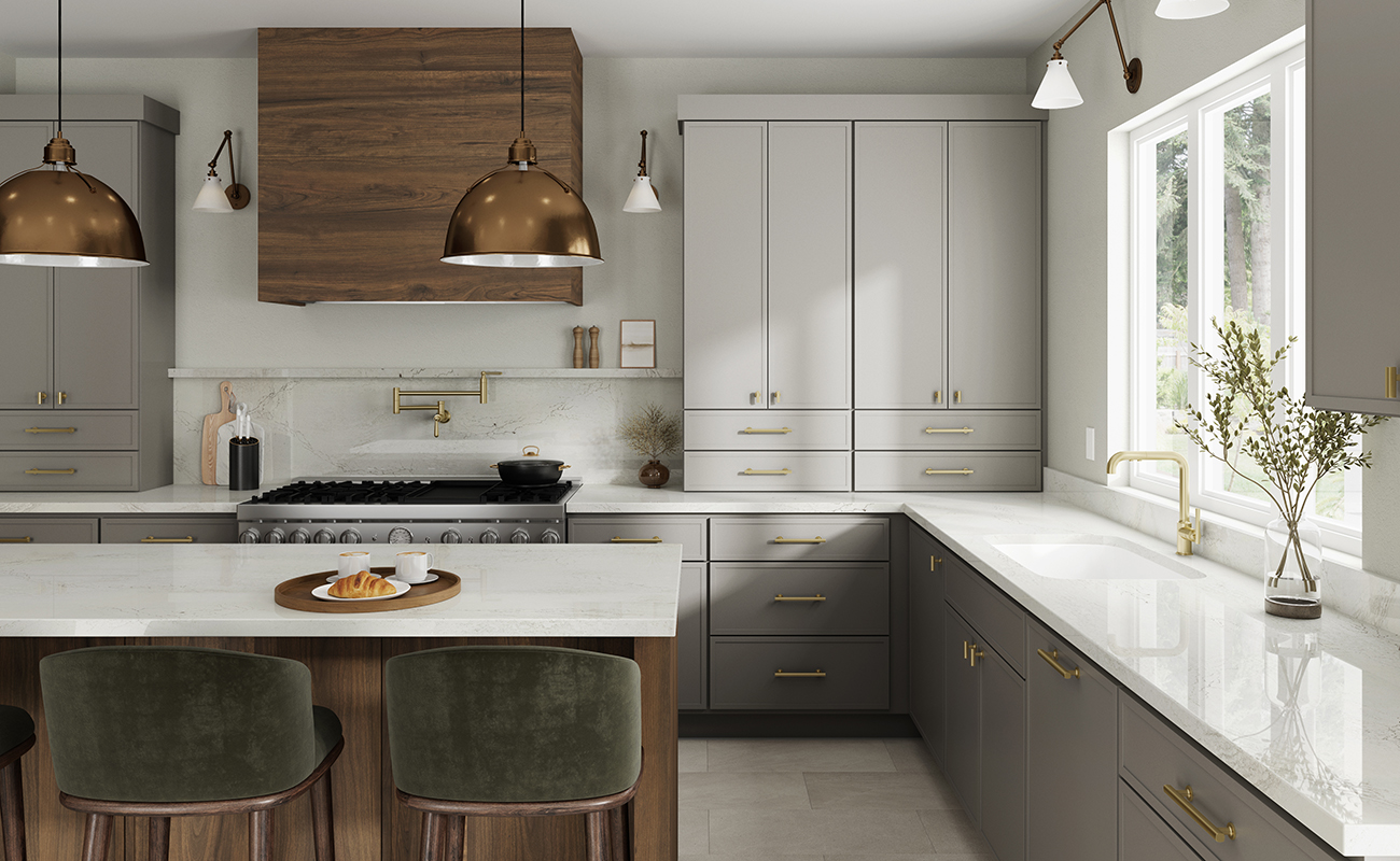 A remodeled kitchen with light gray painted cabinets with a skinny shaker door style contrasted by a medium true-brown stained modern wood hood and kitchen island with shiplap details.