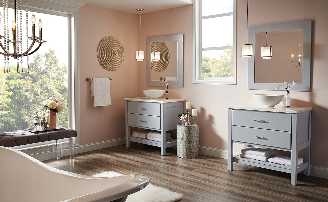 A light gray-blue dual furniture vanities and matching framed mirrors with open shelves below in a chic master bath.