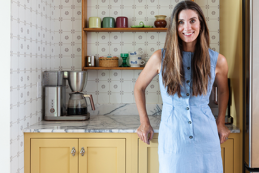 A happy customer with her custom yellow painted inset cabinets from Bertch Cabinet.