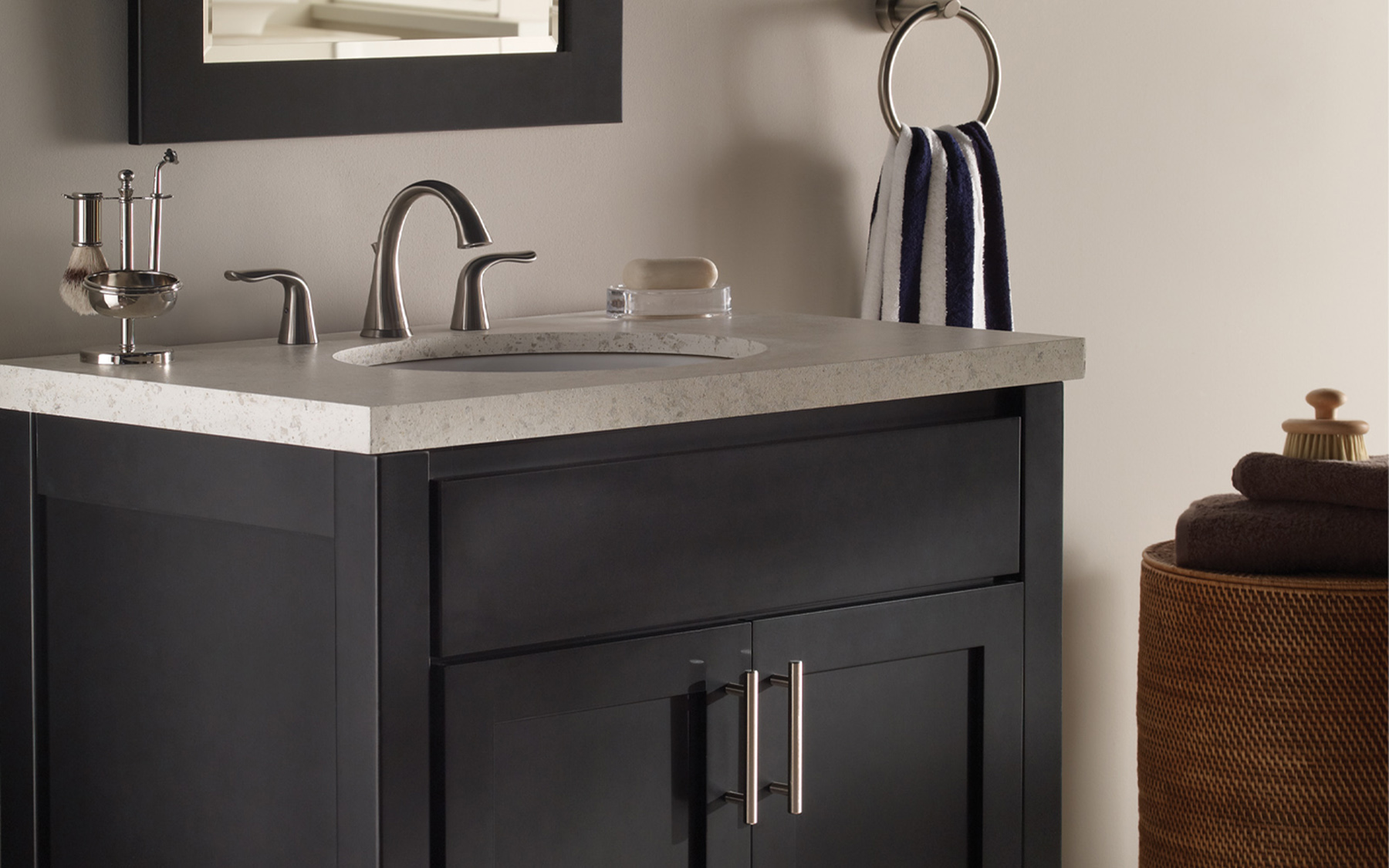 A transitional styled bathroom with sleek black painted vanity cabinets and a black framed mirror.