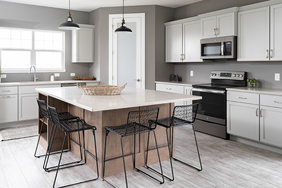 A modern, transitional kitchen with two-toned white and true-brown cabinets using a simple shaker door style.