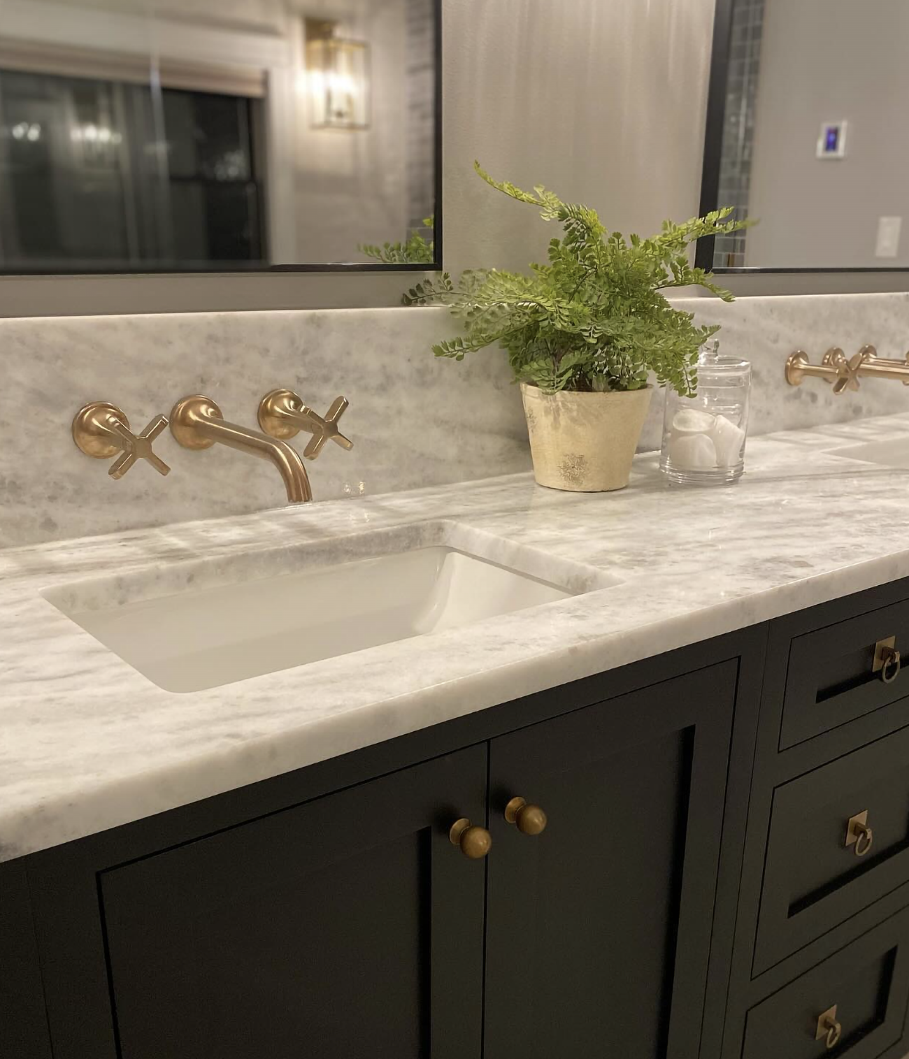 A close up of a black painted vanity with a black framed mirror.