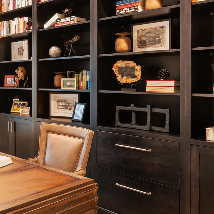 Dark brown stained built-in home office bookshelves and cabinetry.