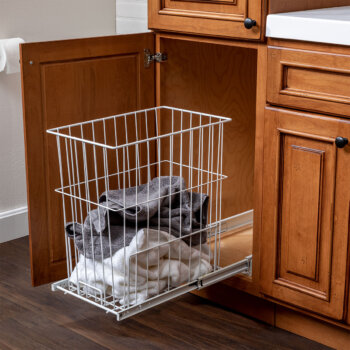 A roll-out hamper hidden inside a cabinet. Storage solutions by Bertch.