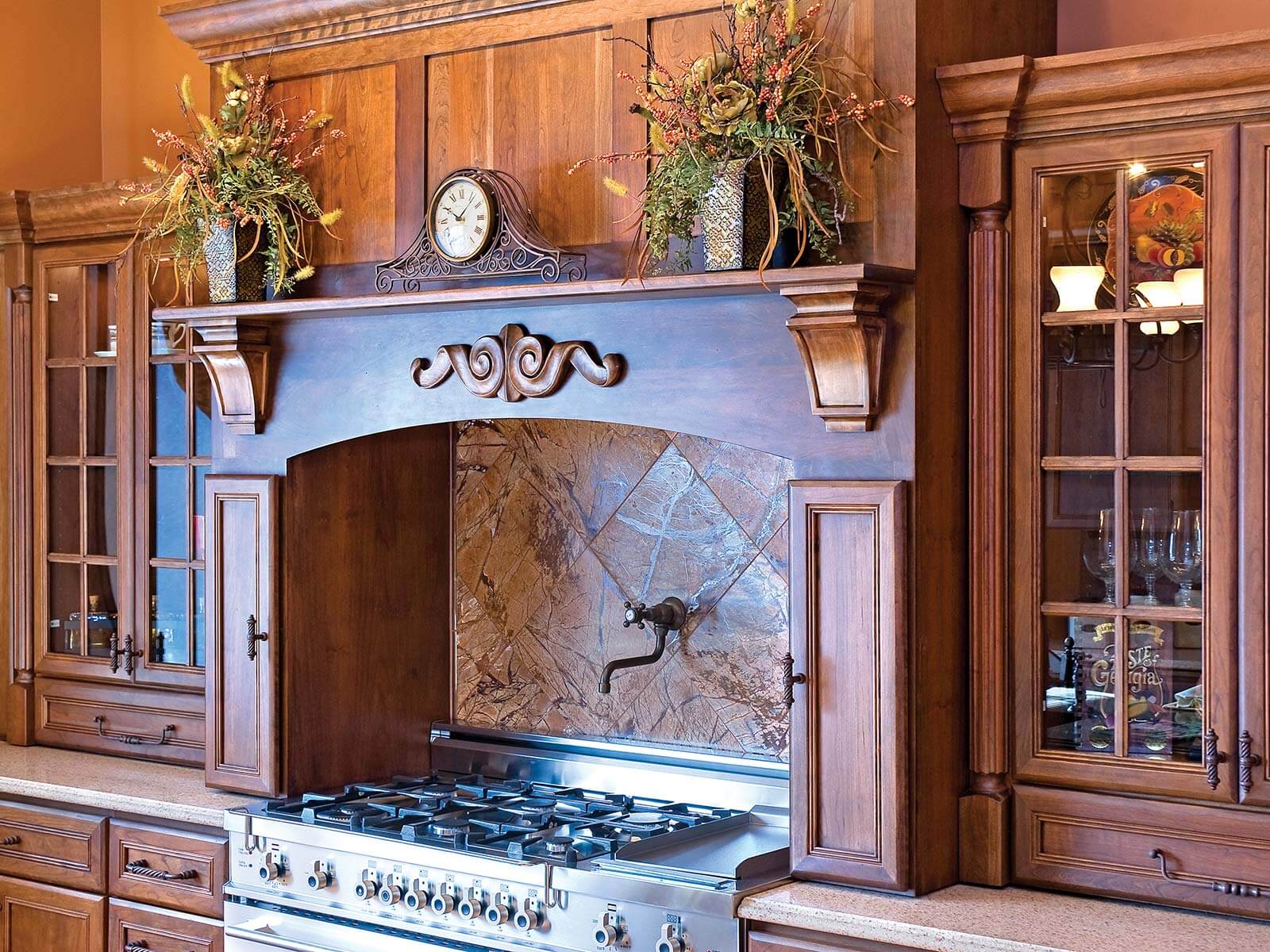 Kitchen wood hood and mantel shelf design in a traditional styled kitchen with ornate details.