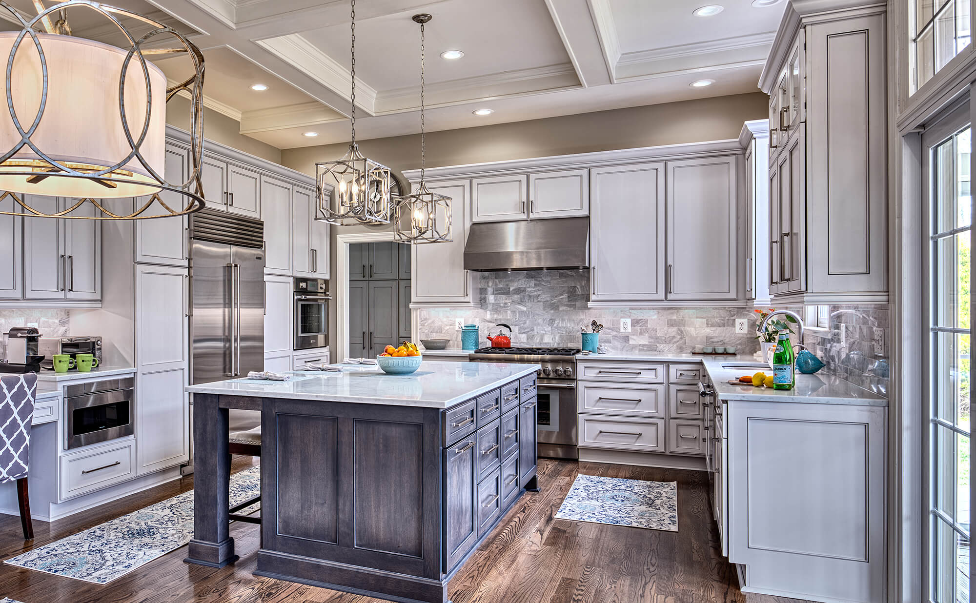 Bright white and cool gray transitional kitchen design with grand kitchen island featuring a stunning gray stained finish.