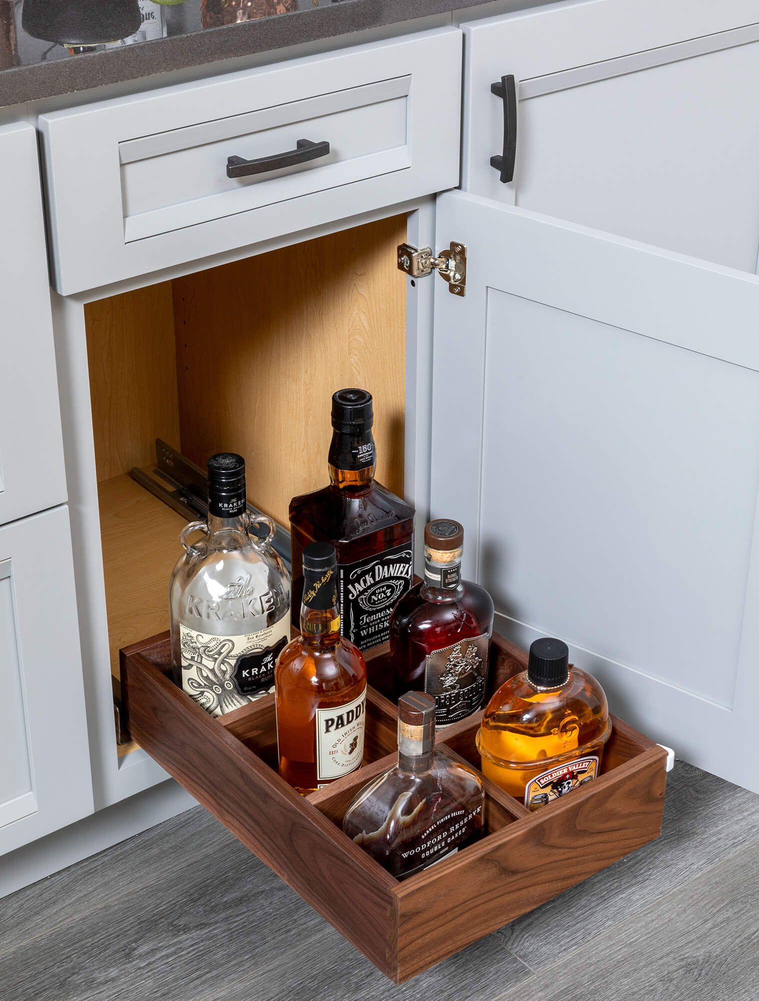 Roll-out shelf with bottle storage for a home bar or pantry.