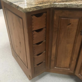 This charming row of vertically stacked apothecary styled drawer boxes is finished to match the exterior of the cabinet.