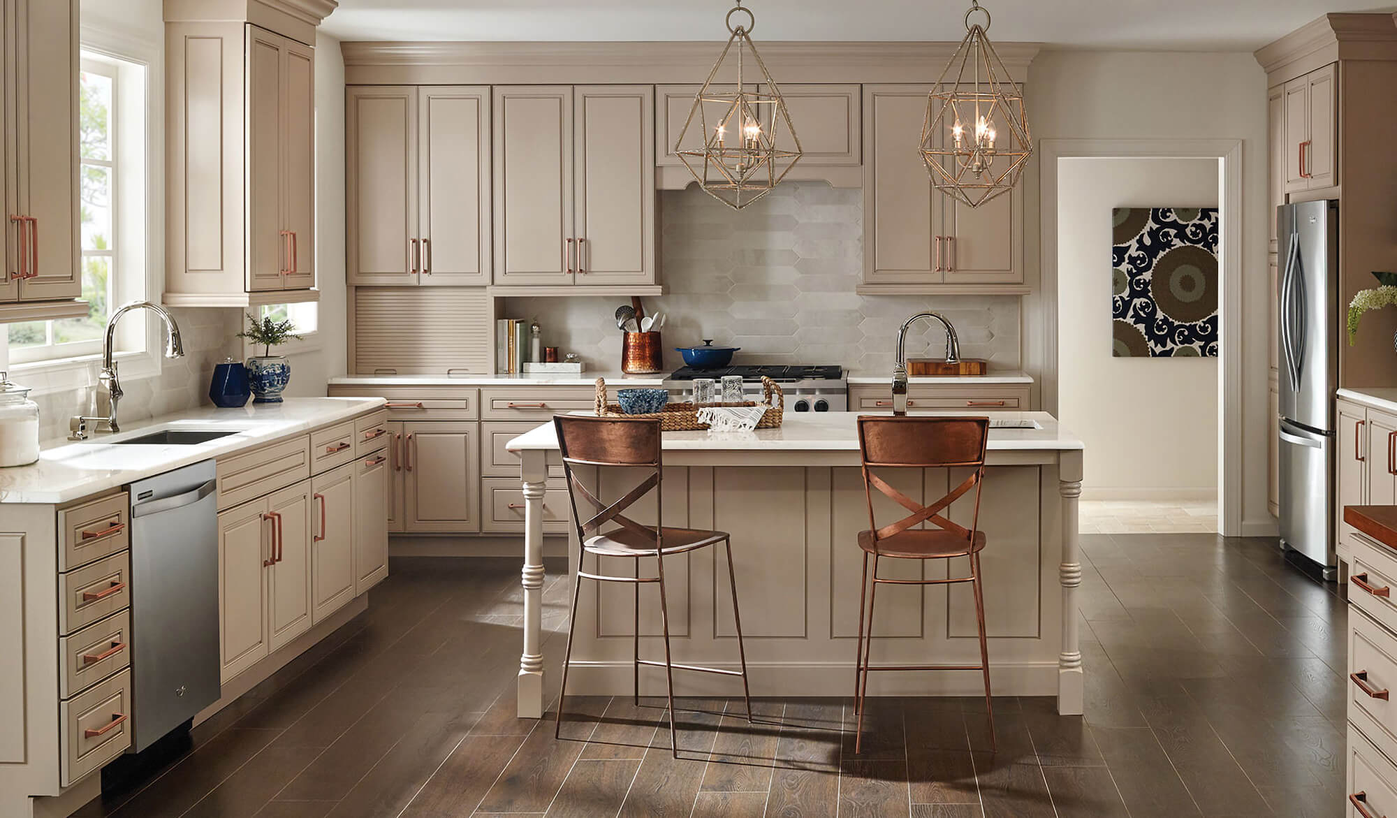 An off-white, beige kitchen with brassy copper hardware.