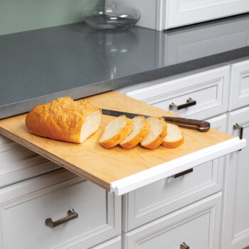 Bertch's pull-out wooded cutting board hides neatly above a kitchen drawer and is ready to go at your convenience.