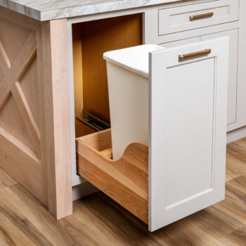 This pull-out cabinet from Bertch stores a single wastebasket and dedicated space for housing wastebasket liners.