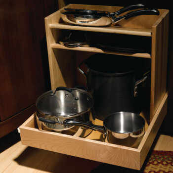 An entire cookware collection can be organized neatly in this single pull-out that houses pots and pans and organizes lids above.