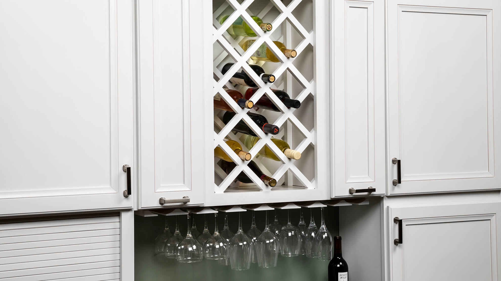 Home bar wall cabinets with a wine rack and under the cabinet stemware rack for wine glass storage.