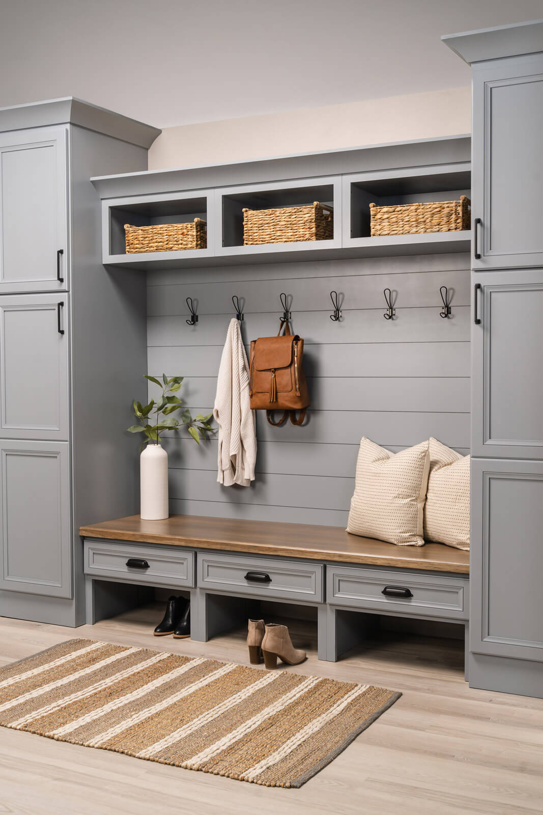 Bertch mudroom featuring stylish shiplap, seating, and tall linen cabinetry in Loft on Paintable